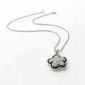 Silver necklace with a clover-shaped pendant on a white background